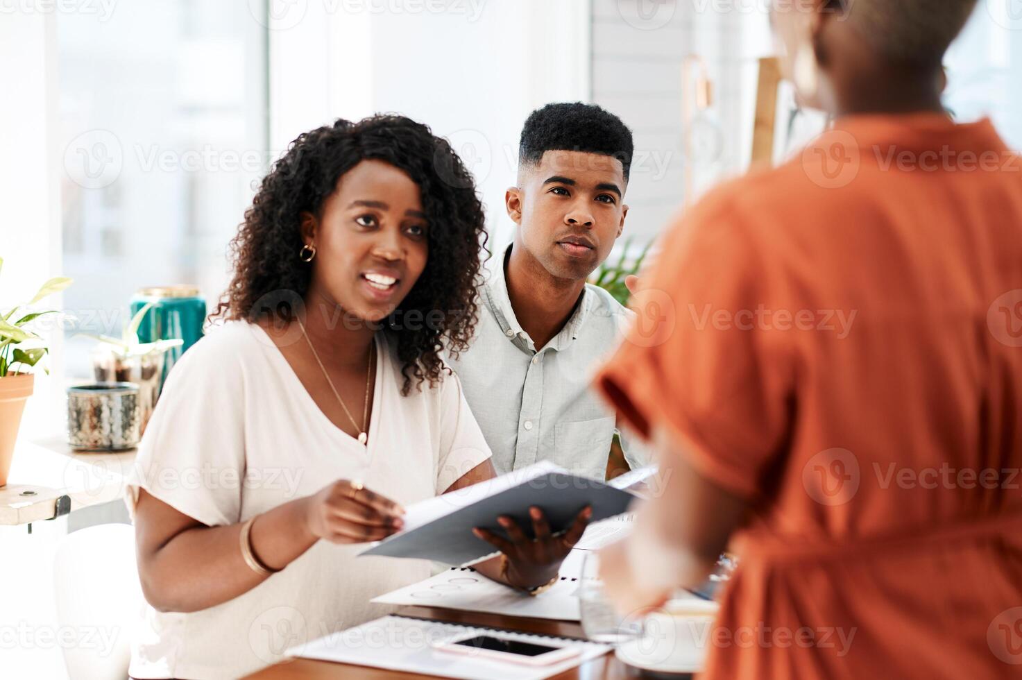 A financial advisor reviewing a portfolio with clients at a desk